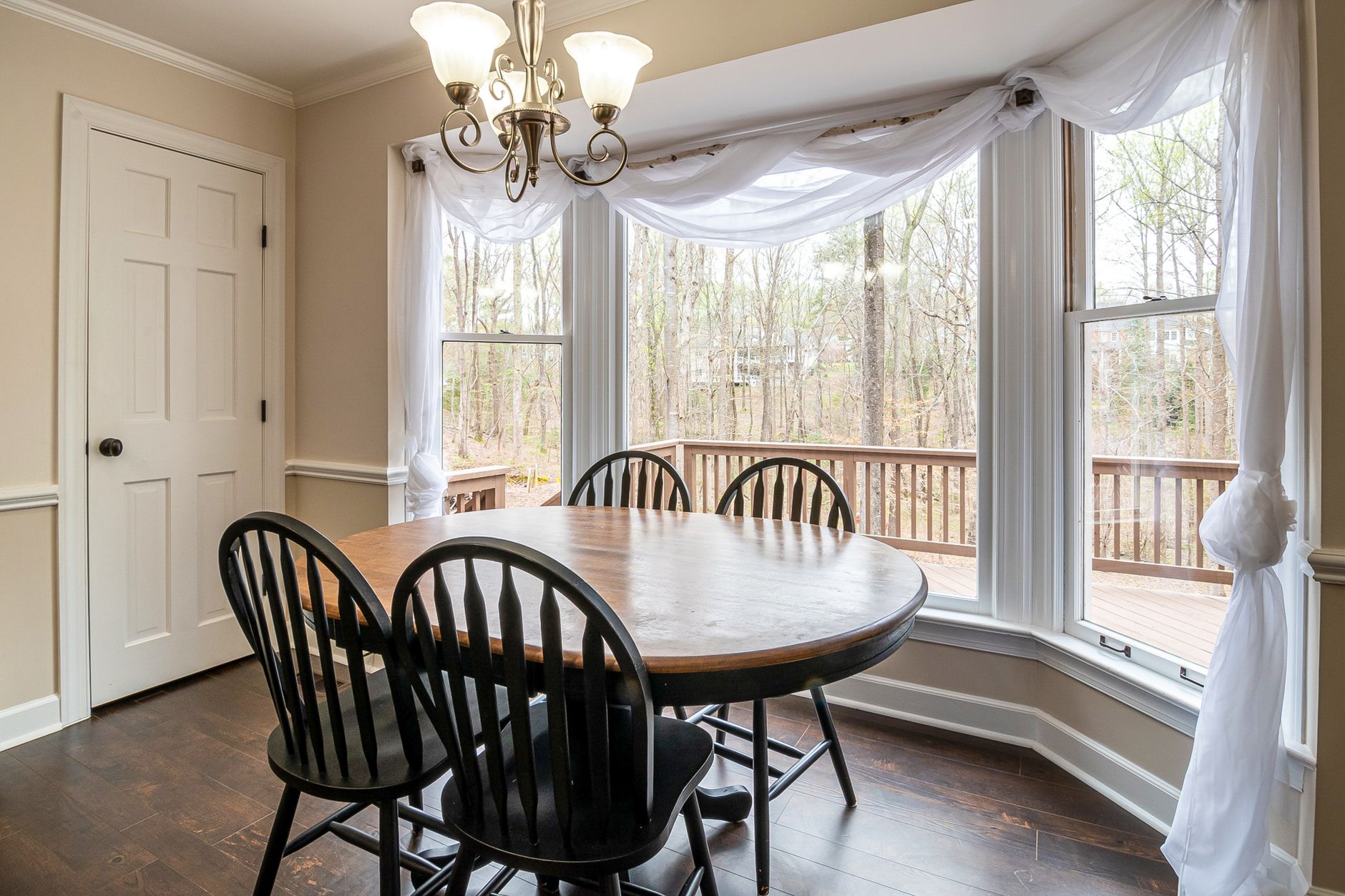 Bright dining area featuring a wooden table and chairs with a view of the outdoors through large windows in Austin, TX